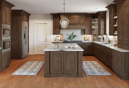 Elegant dark wood kitchen with island, marble countertops, stainless steel appliances, and area rugs.