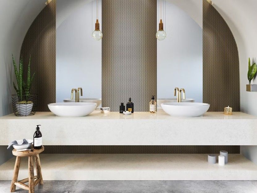 Bathroom with double sinks, arched mirrors, brass fixtures, and neutral tones.