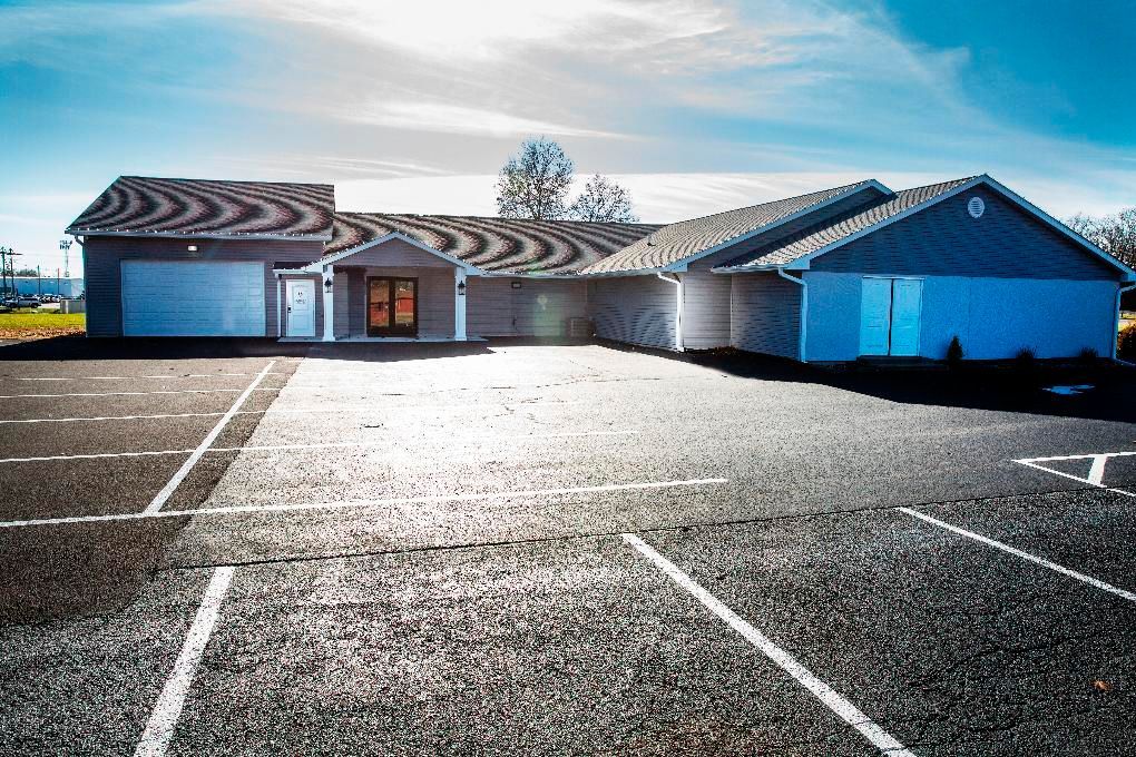 Empty parking lot in front of a low building under a bright sky