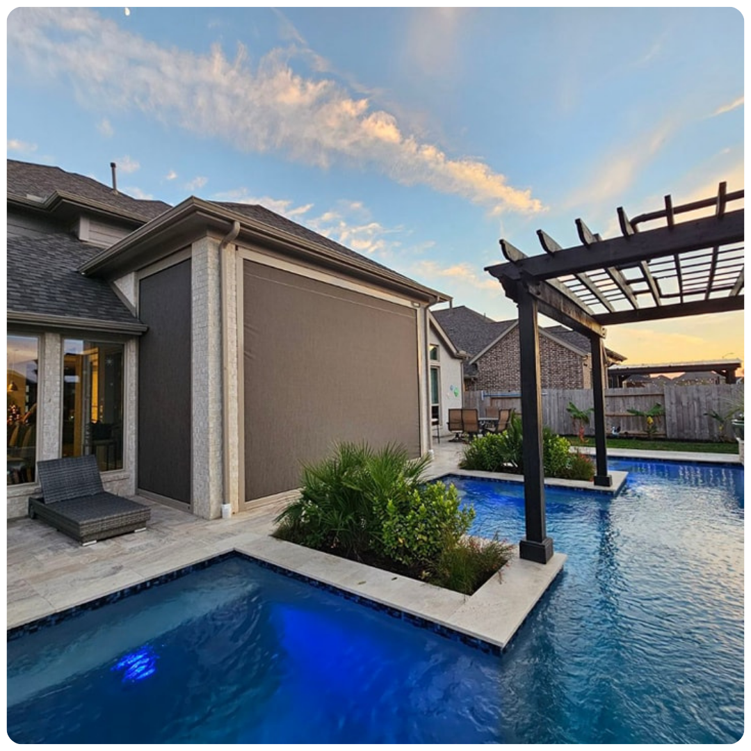 There is a large swimming pool in the backyard of a house.