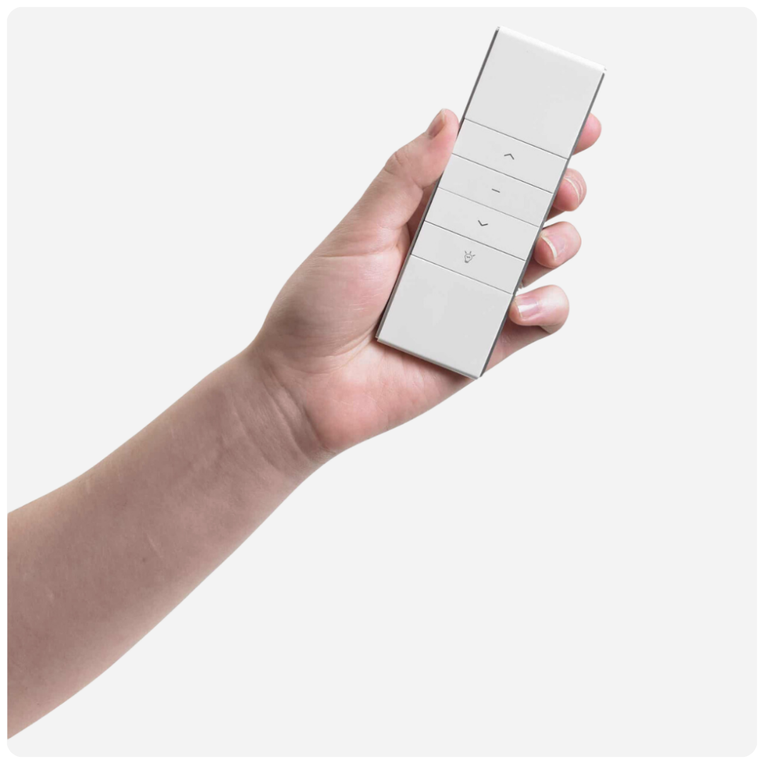 A person is holding a white remote control in their hand