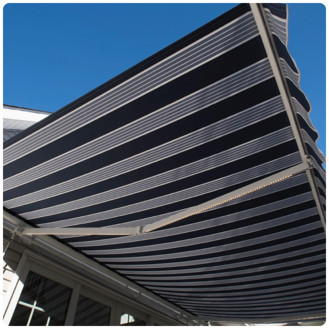A black and white striped awning with a blue sky in the background