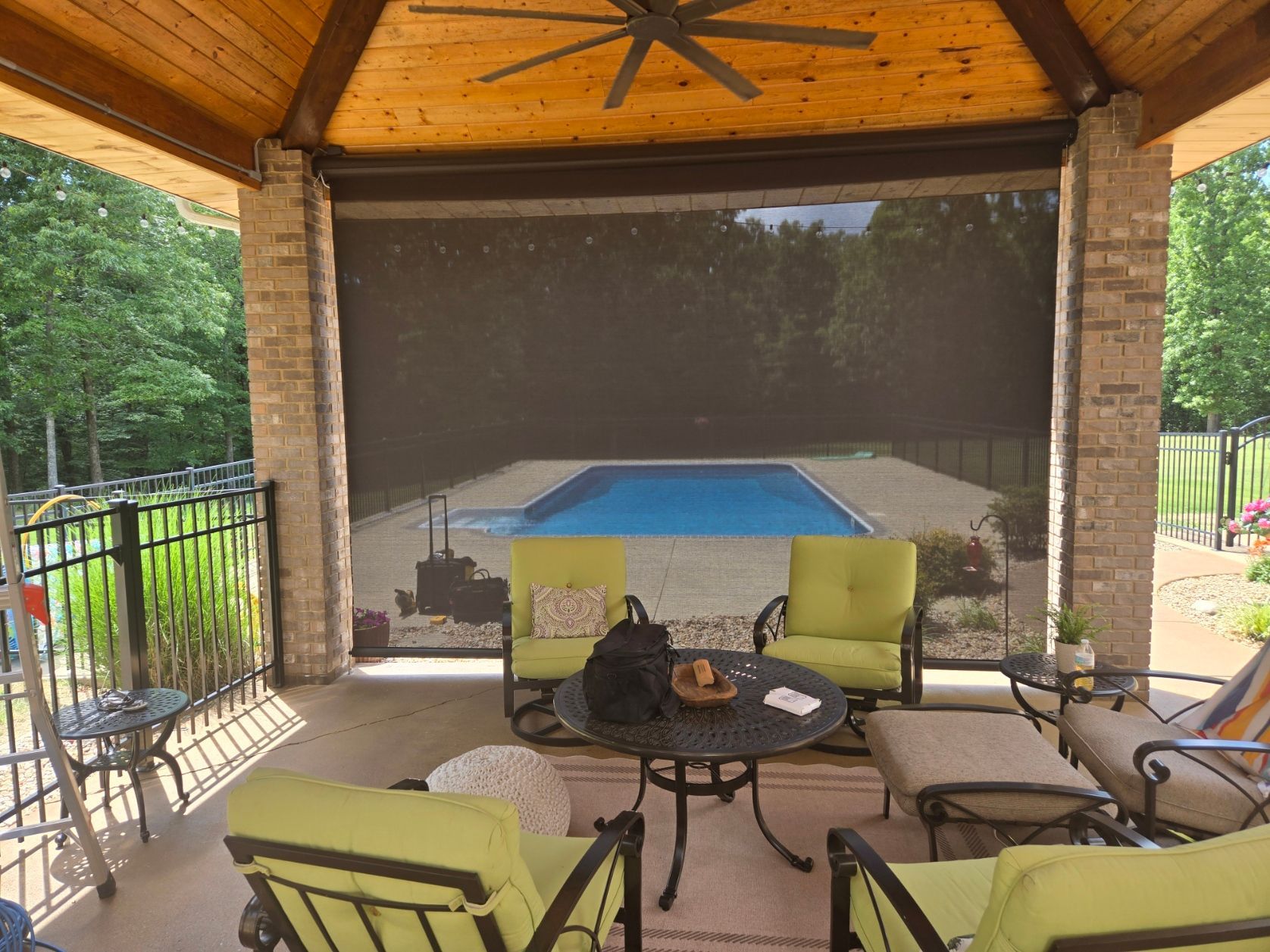 large swimming pool in the backyard of a house with motorized patio shades texas