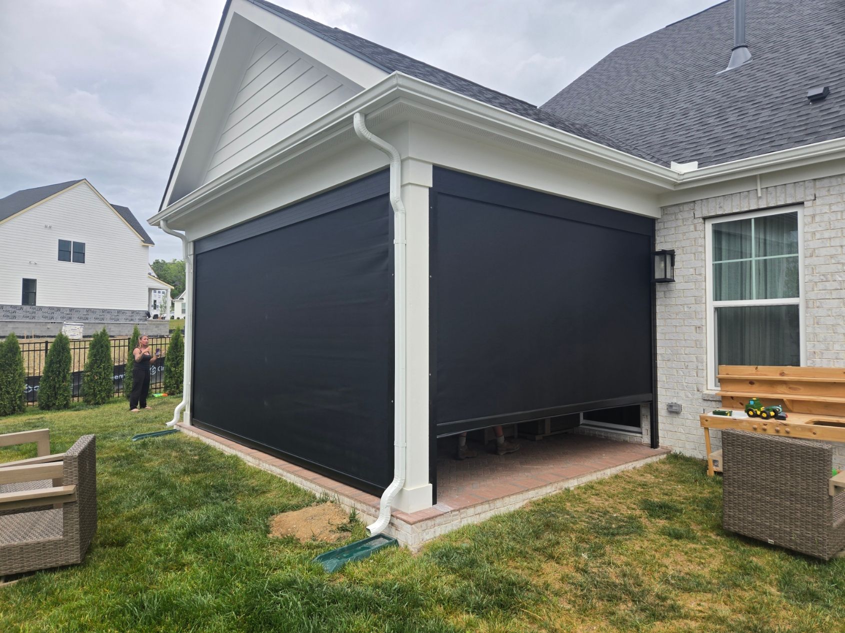 A large swimming pool with a electric shades for patio in the backyard of a house in texas.