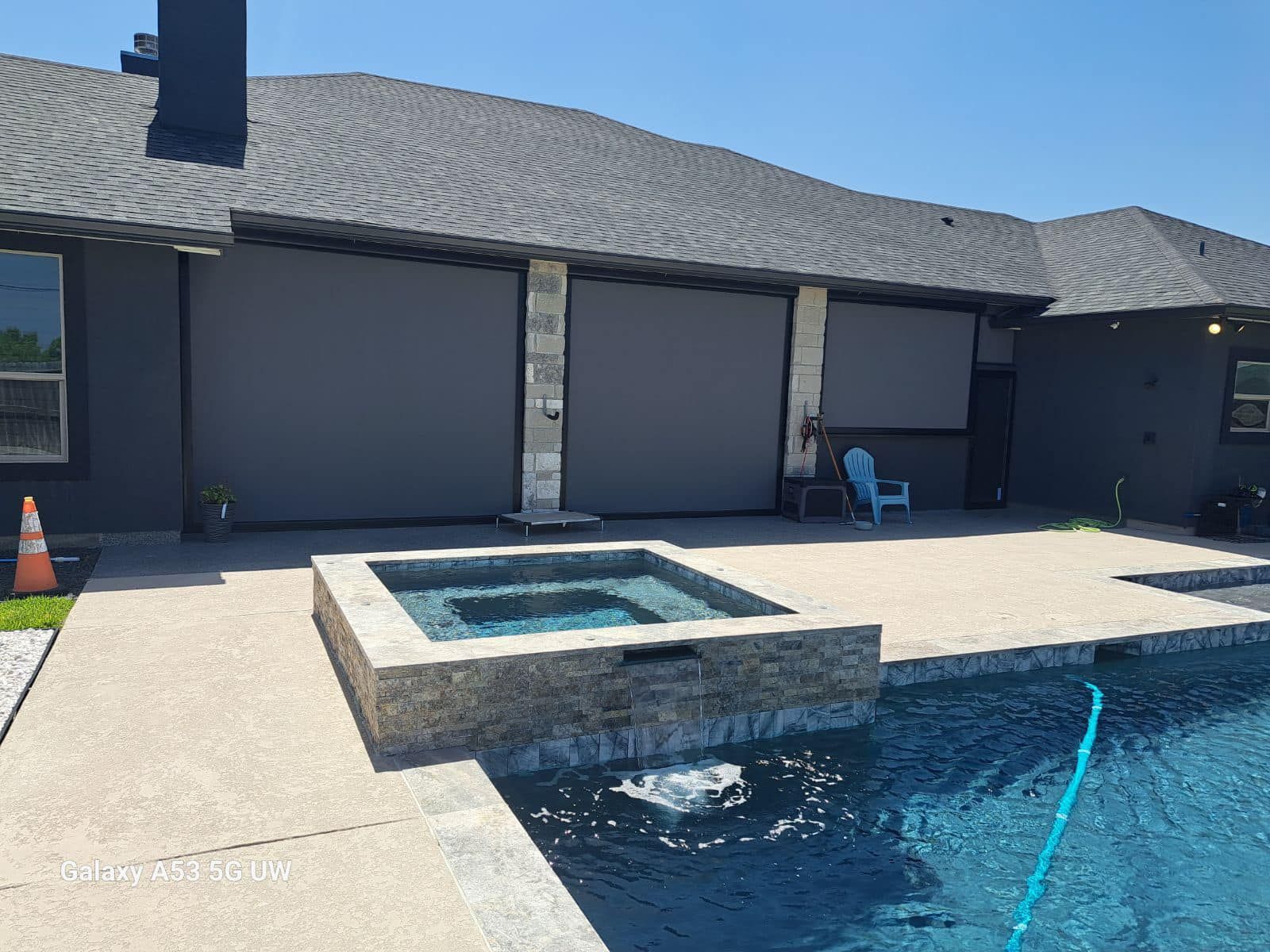 There is a swimming pool in the backyard of a house.
