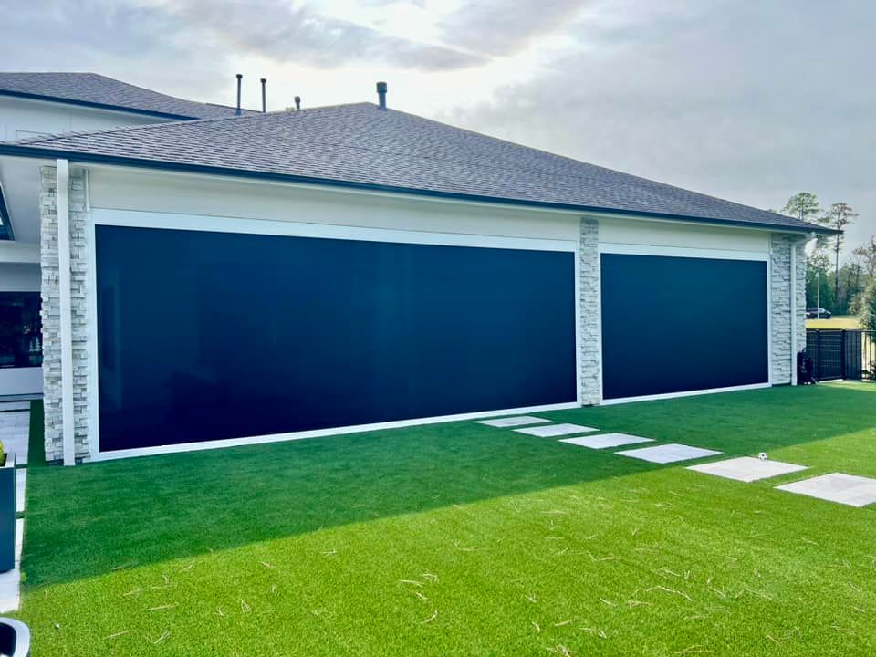 A house with a lot of windows and a lawn in front of it.