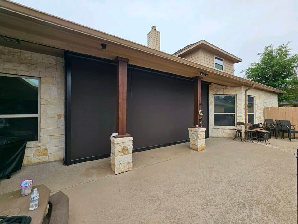 A house with a patio and a screen door on the side of it.