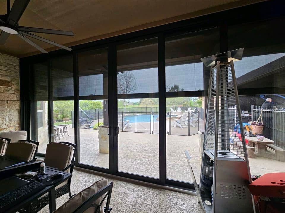 A sun room with sliding glass doors leading to a patio and a pool.