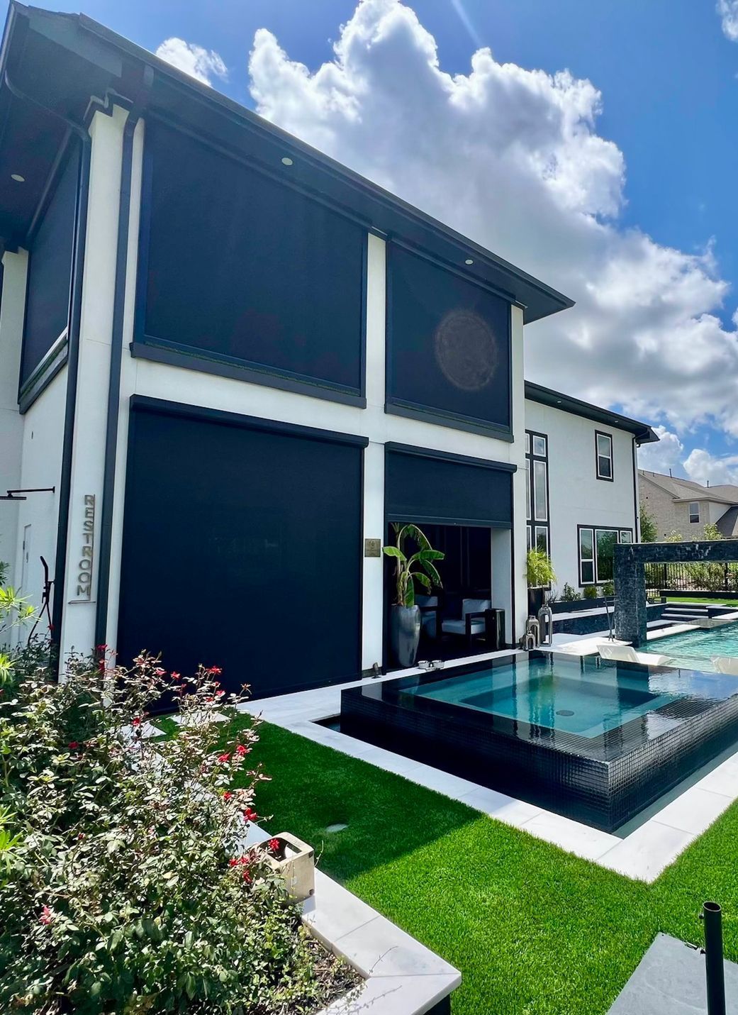 A large swimming pool with a pergola in the backyard of a house.