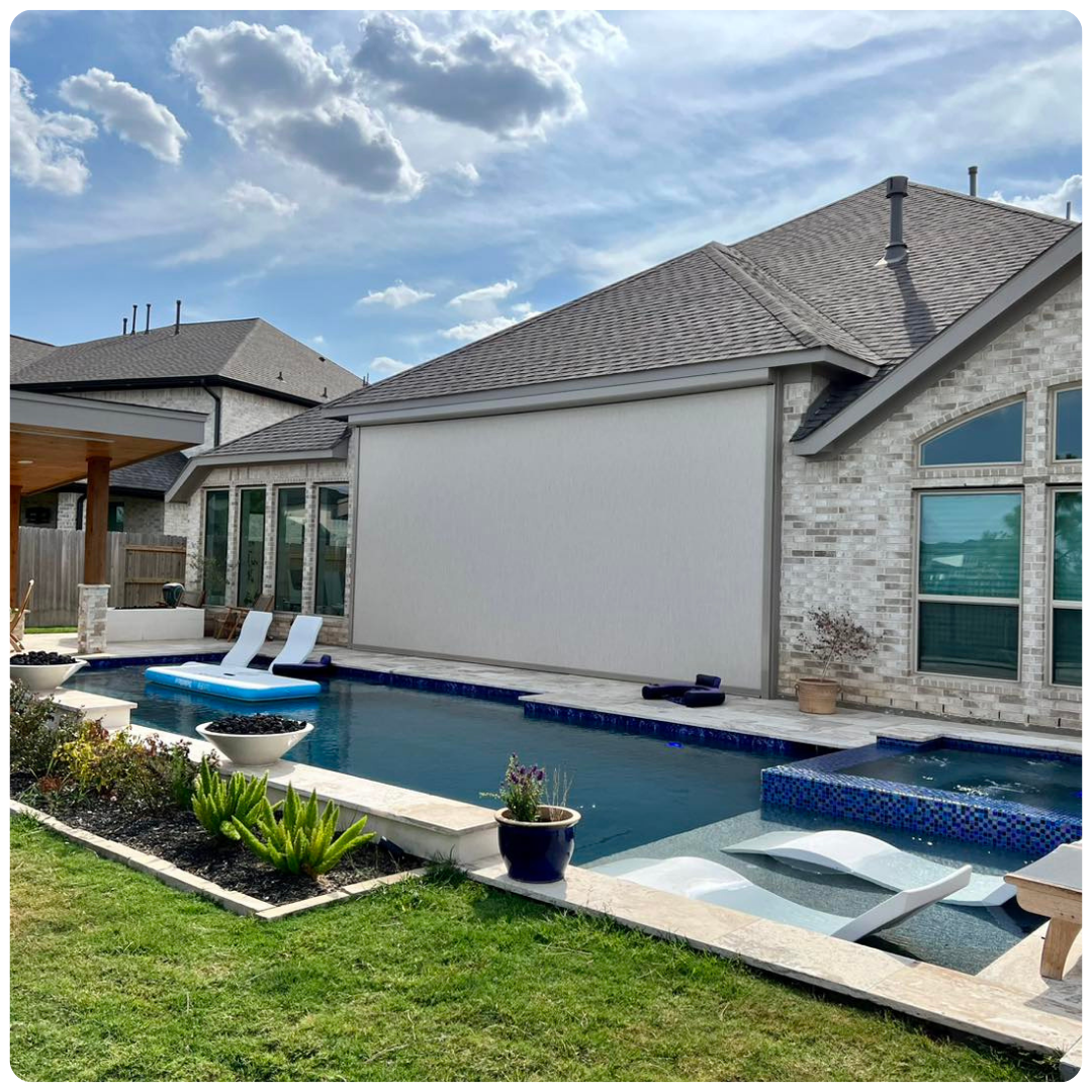 A large swimming pool is in the backyard of a house.