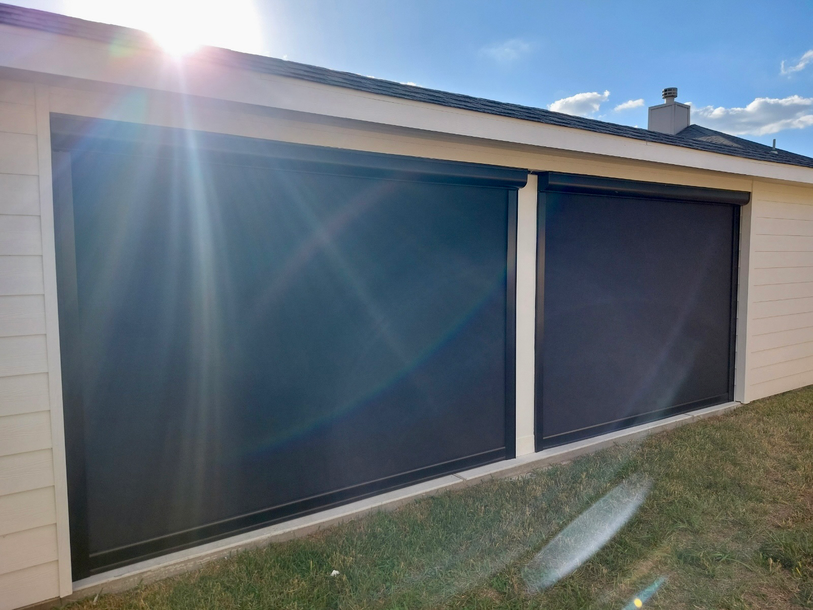 The sun is shining through the blinds on the side of a house.