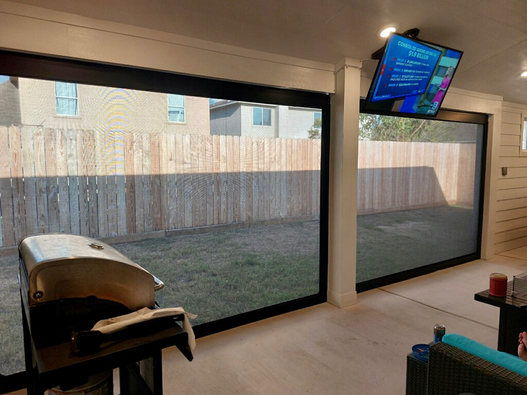 A living room with a grill and a television on the wall.