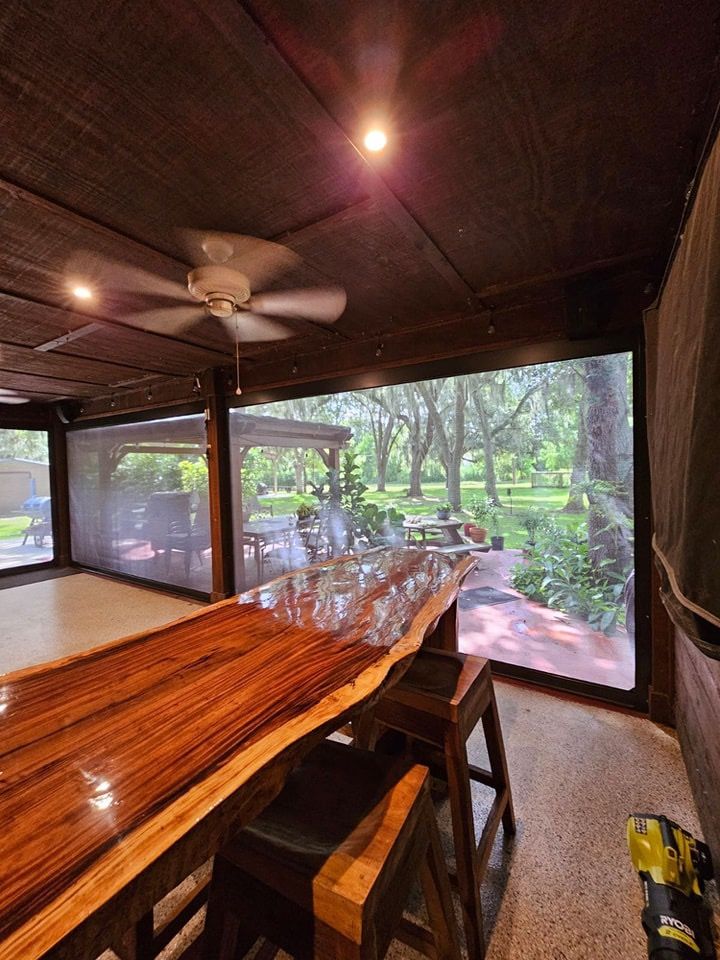 A wooden table and chairs in a room with a ceiling fan.