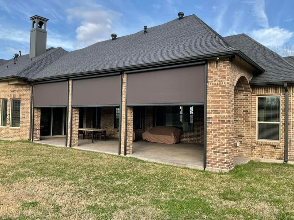 A large brick house with a patio and a screened in porch.
