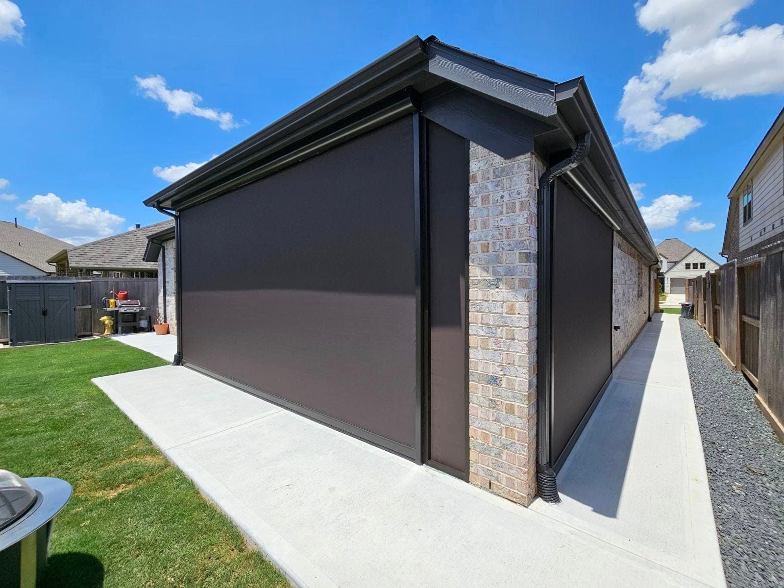 A house with a walkway leading to it and custom outdoor shades in texas.