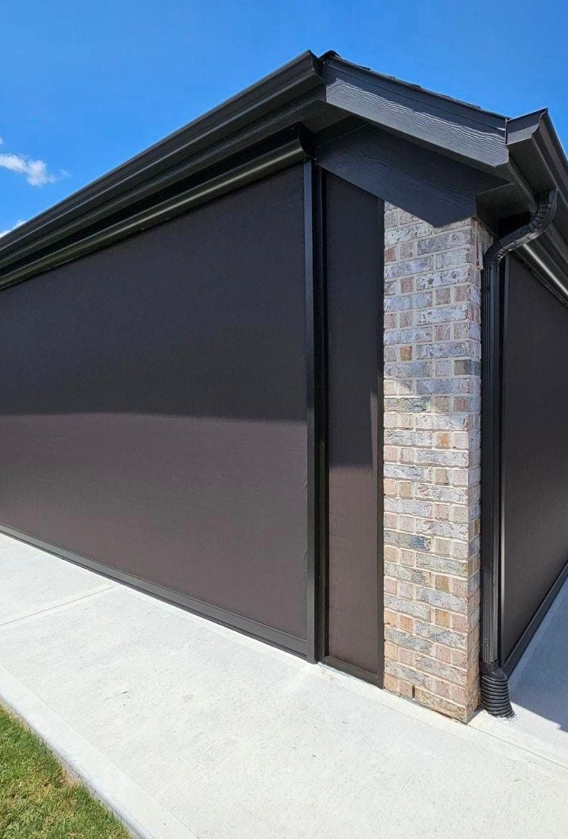 A house with a brick wall and a gutter on the side of it.