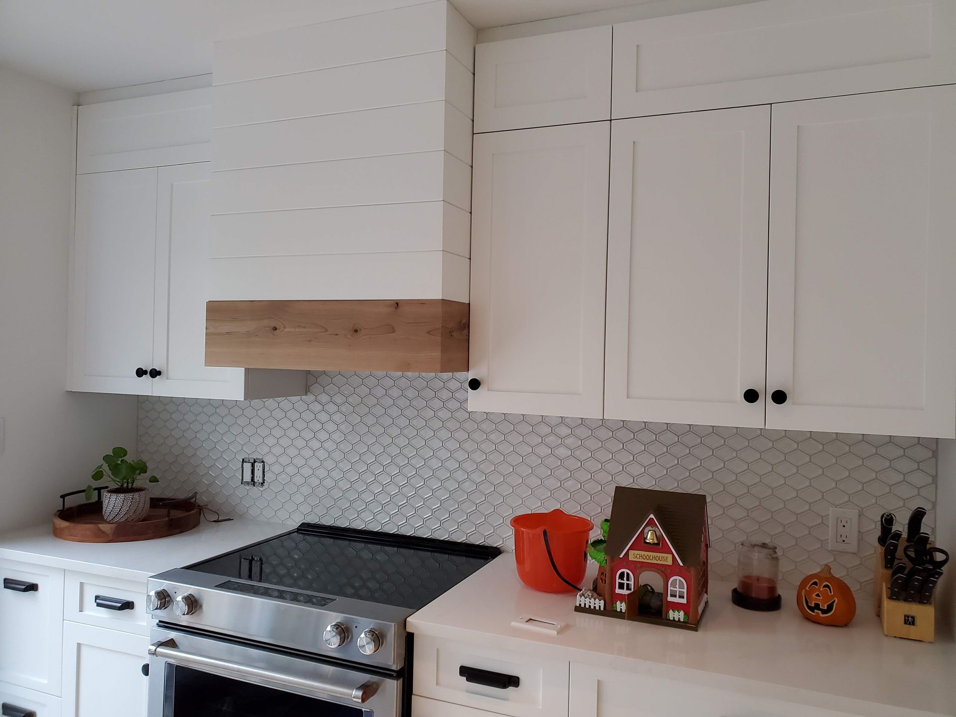Une cuisine avec des armoires blanches et un four sur cuisinière