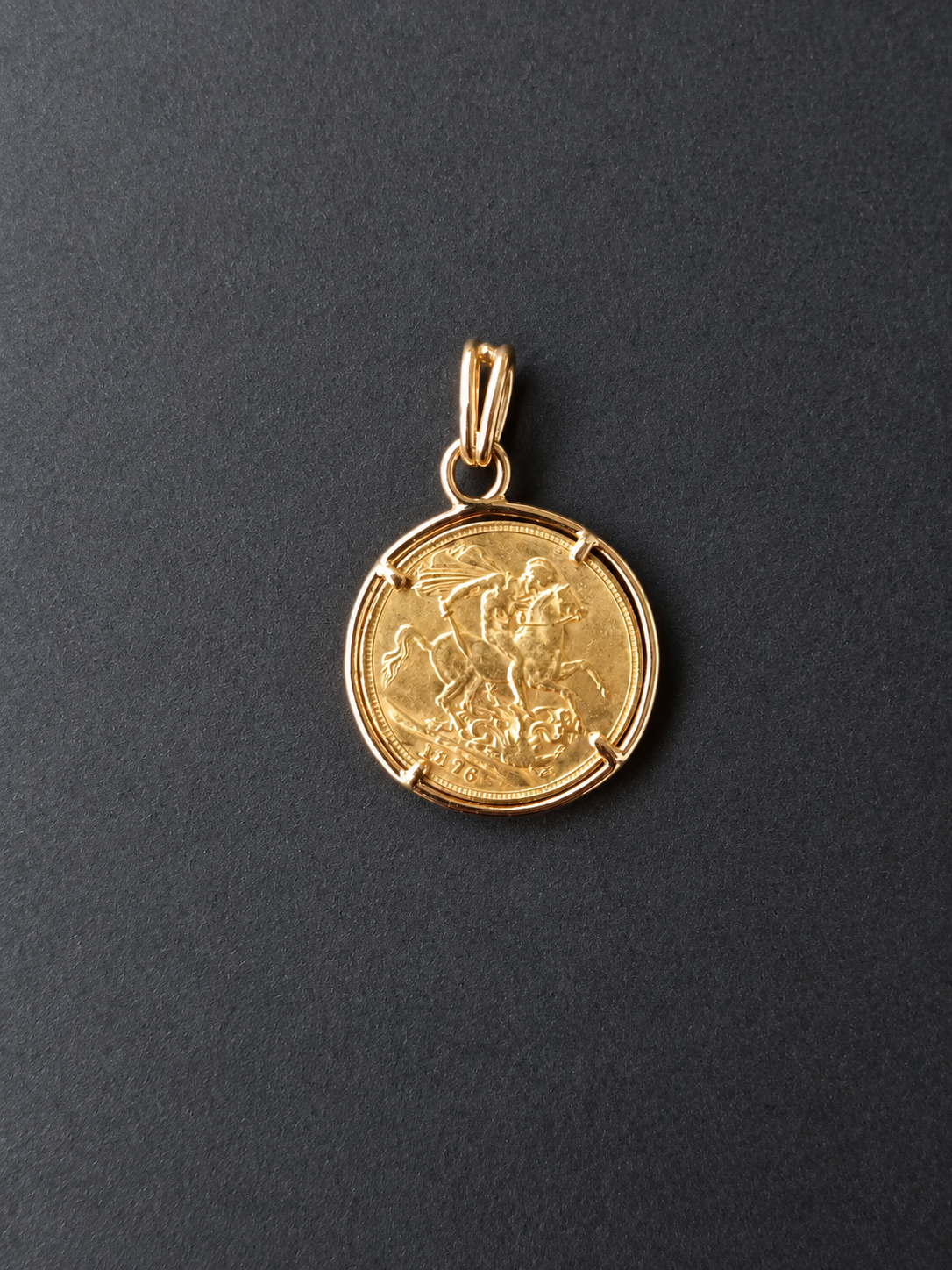 Pendentif en pièce d’or sur fond gris foncé