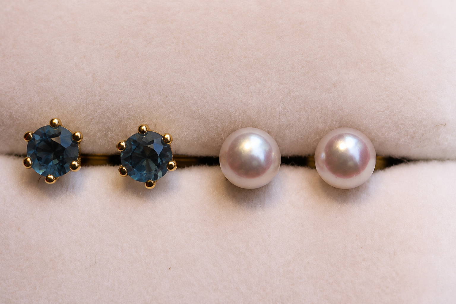 Quatre clous d’oreilles : deux pierres précieuses bleues et deux perles, portés sur la peau