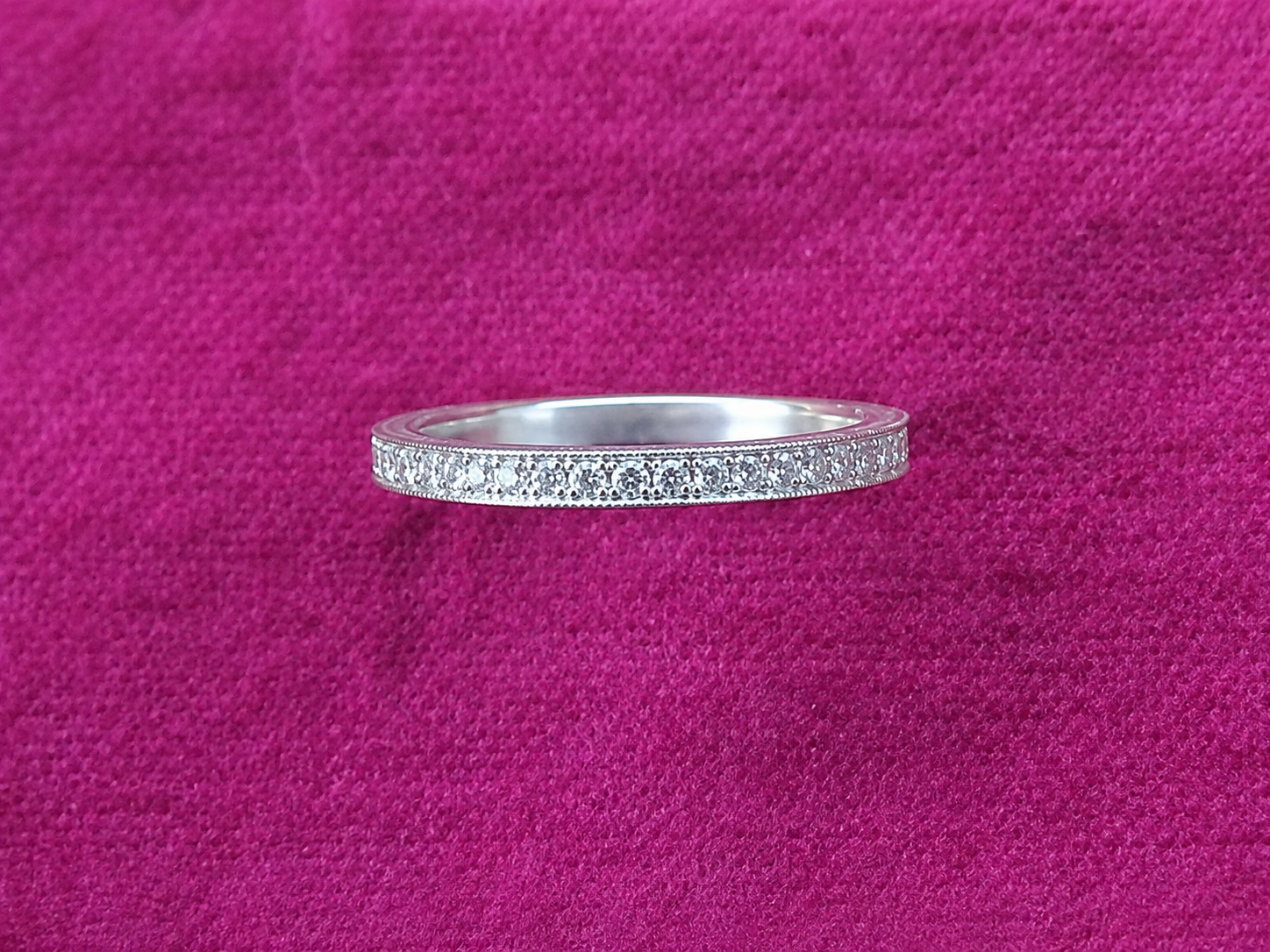 Bague en argent avec un anneau texturé sur un fond en tissu rose vif