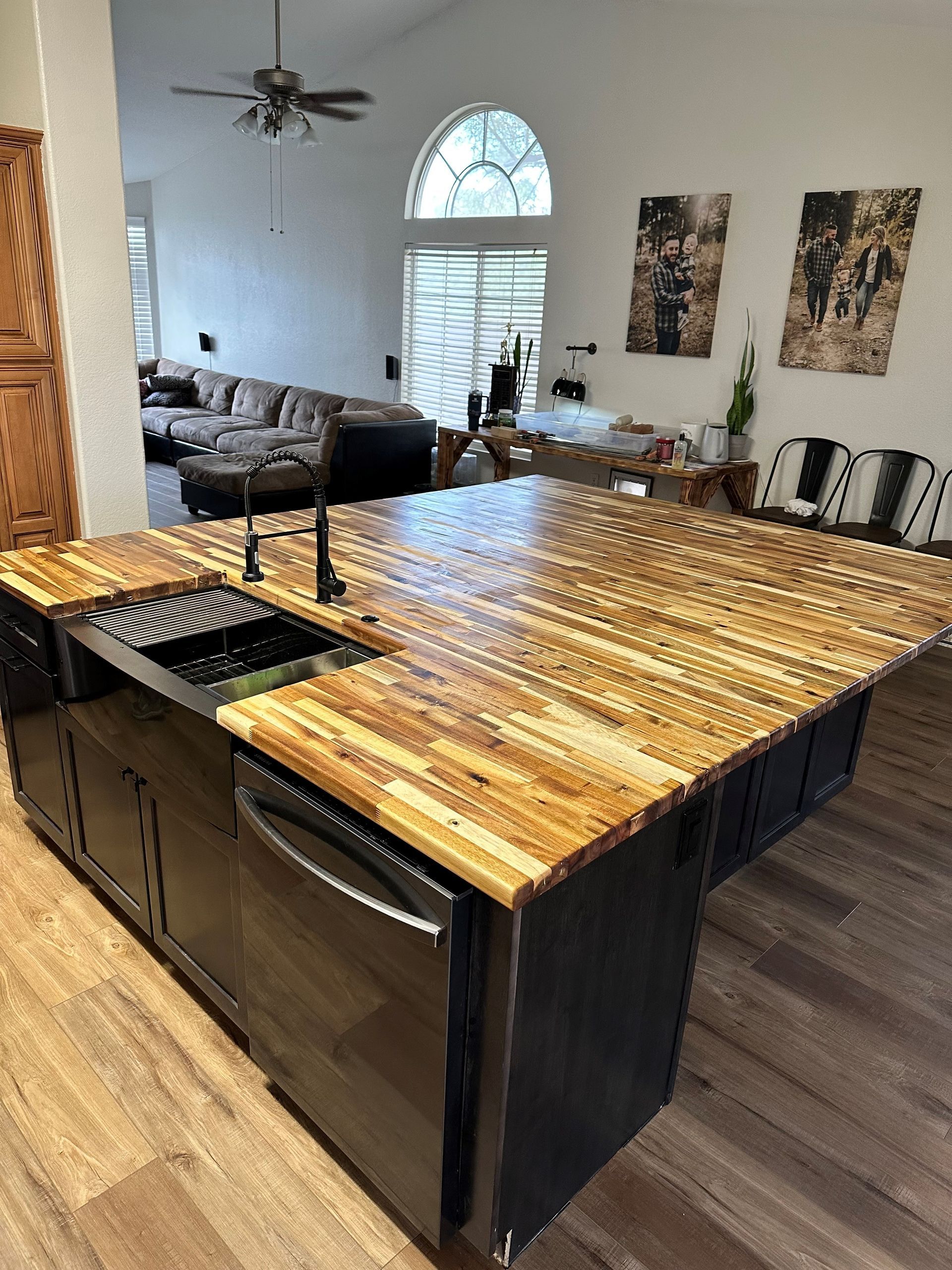 A kitchen with a wooden counter top , sink , and dishwasher.