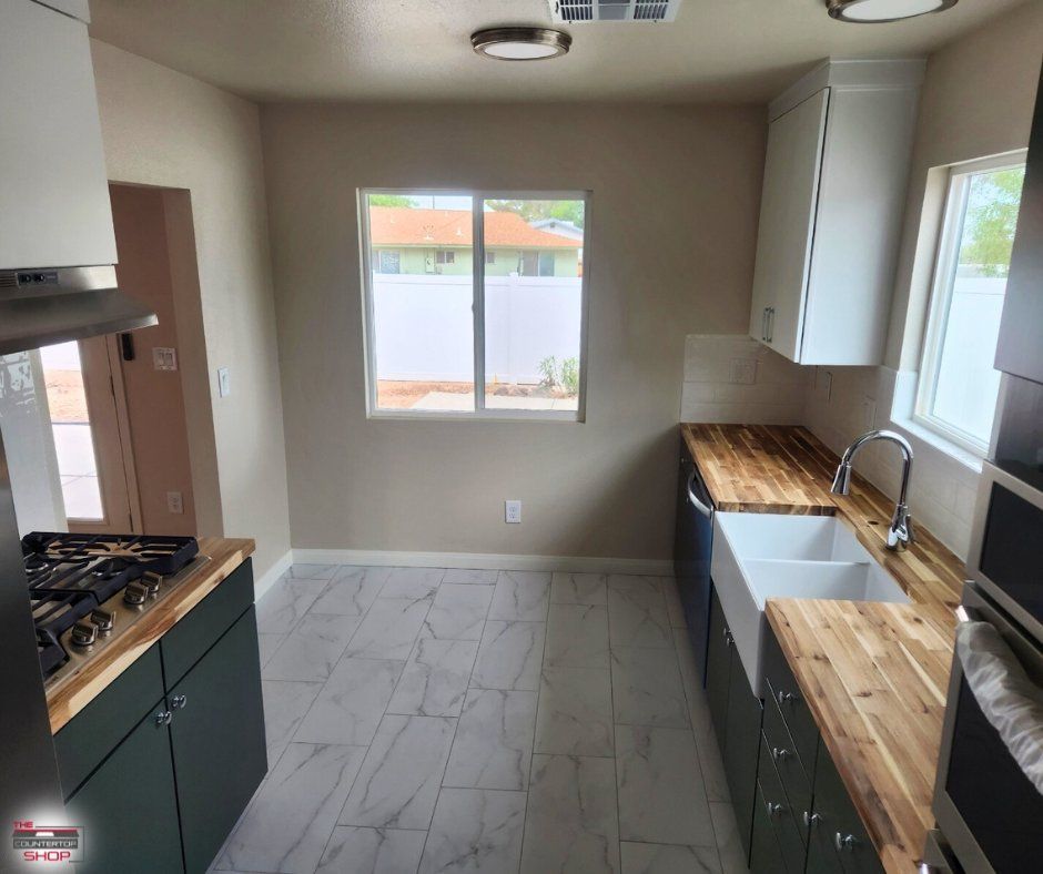 A kitchen with a stove a sink and a window