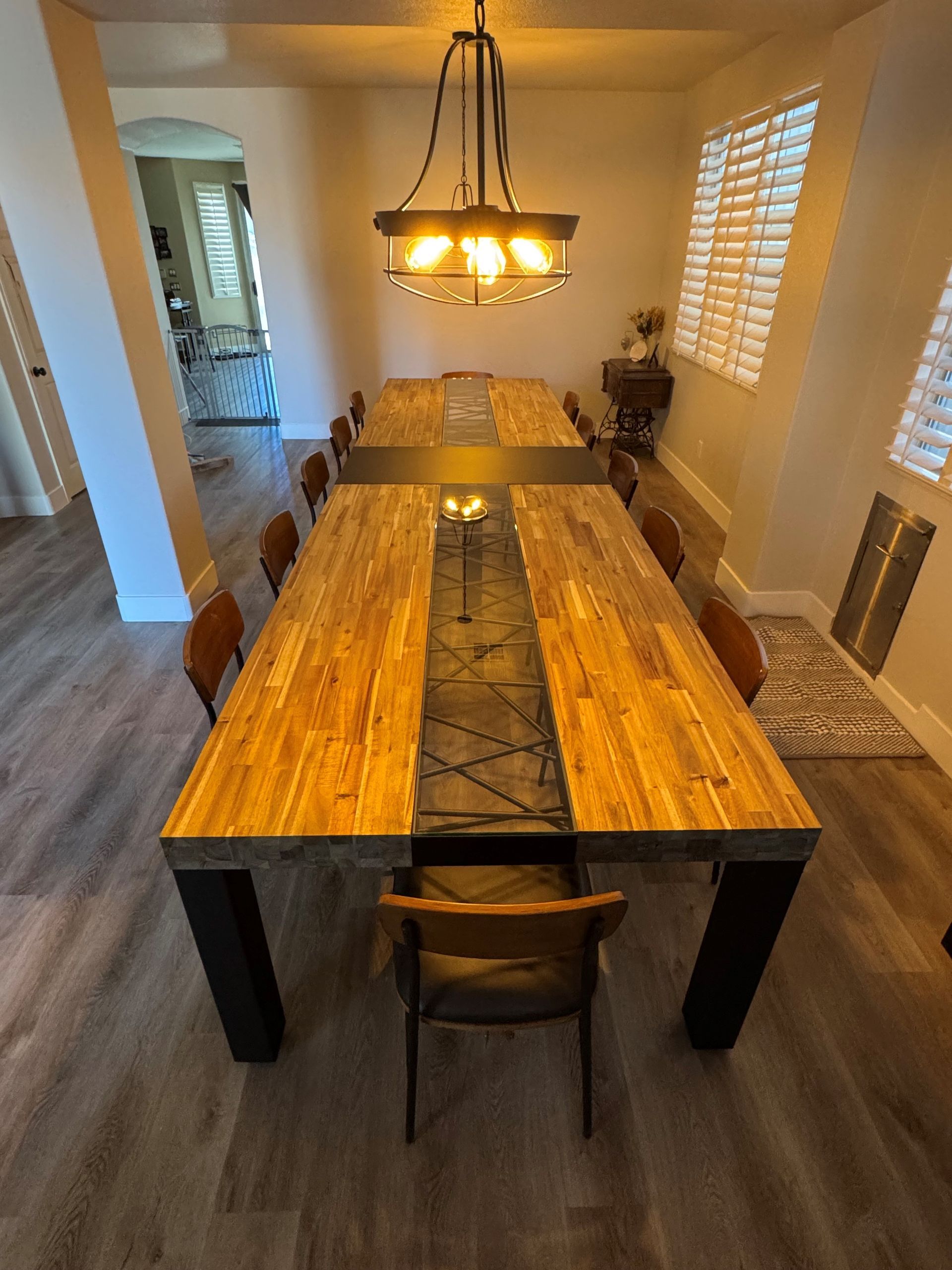 A long wooden dining table with chairs in a dining room.