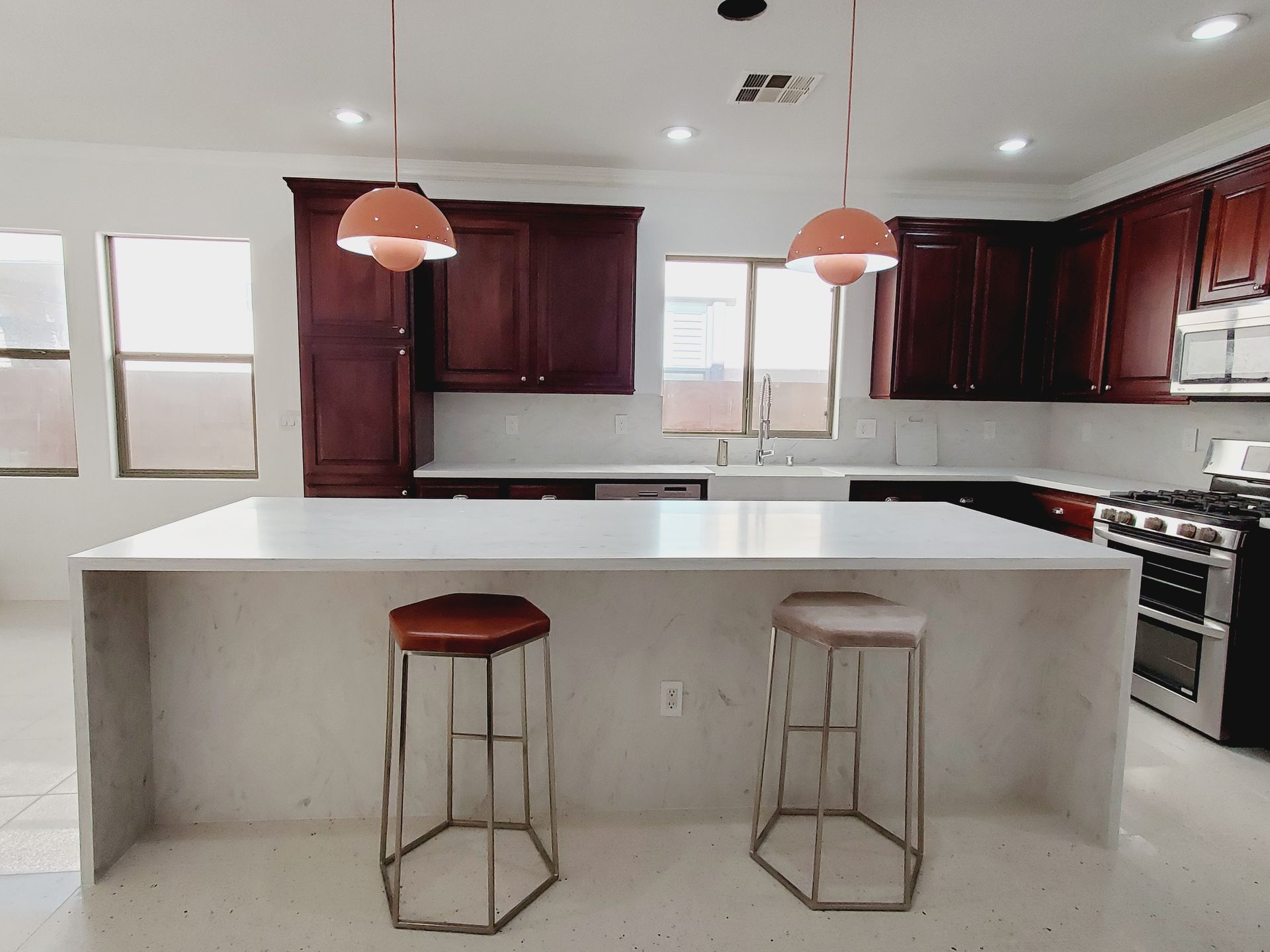 A kitchen with a large island and two stools