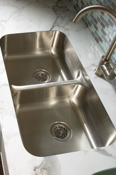 A stainless steel kitchen sink with two drains and a faucet