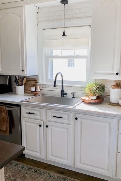 A kitchen counter with a basket of bananas and a vase of flowers.