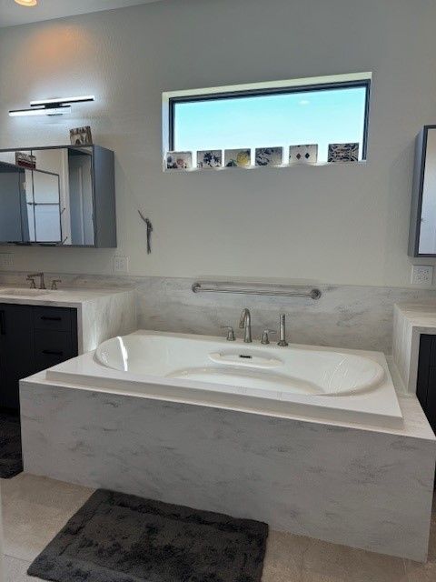 A bathtub in a bathroom with a window above it
