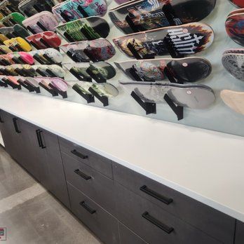 A bunch of skateboards are hanging on a wall