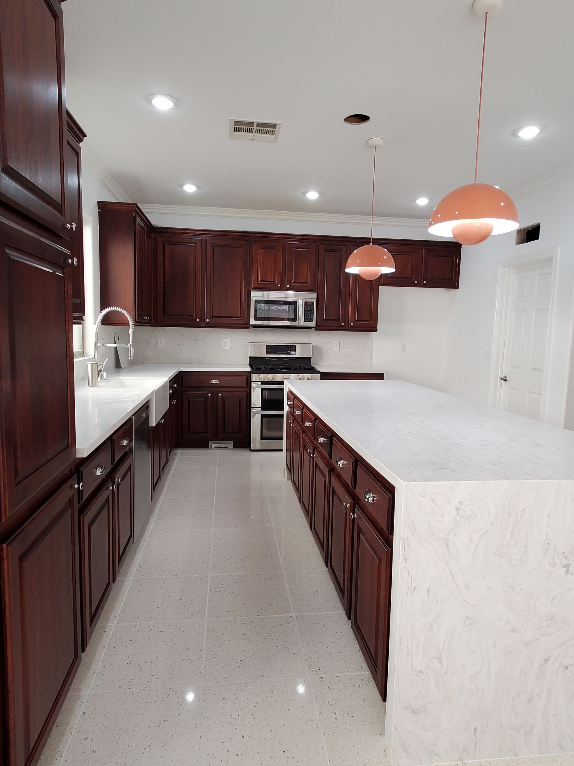A kitchen with wooden cabinets and white counter tops