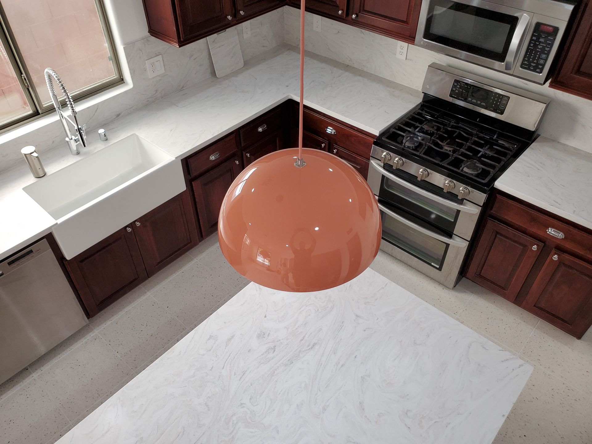 An aerial view of a kitchen with a sink stove and microwave