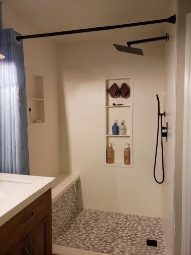 A bathroom with a walk in shower and a sink.