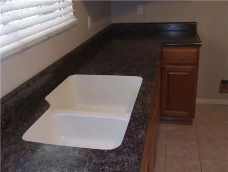 A kitchen counter with a sink and a window.