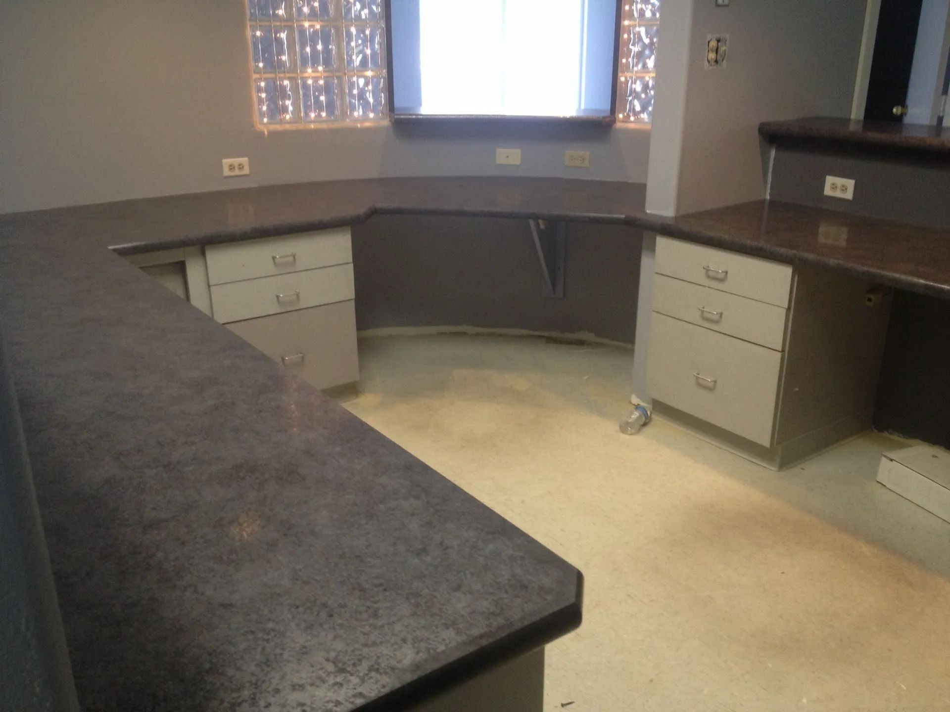 An empty office with a large screen on the wall.