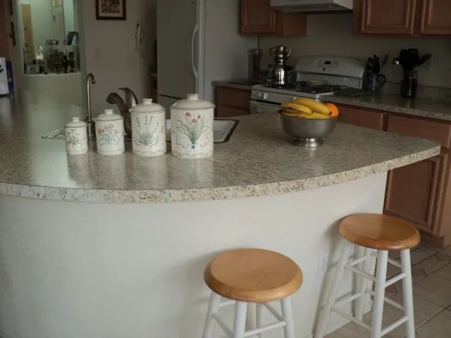 A kitchen counter with a bowl of bananas on it.