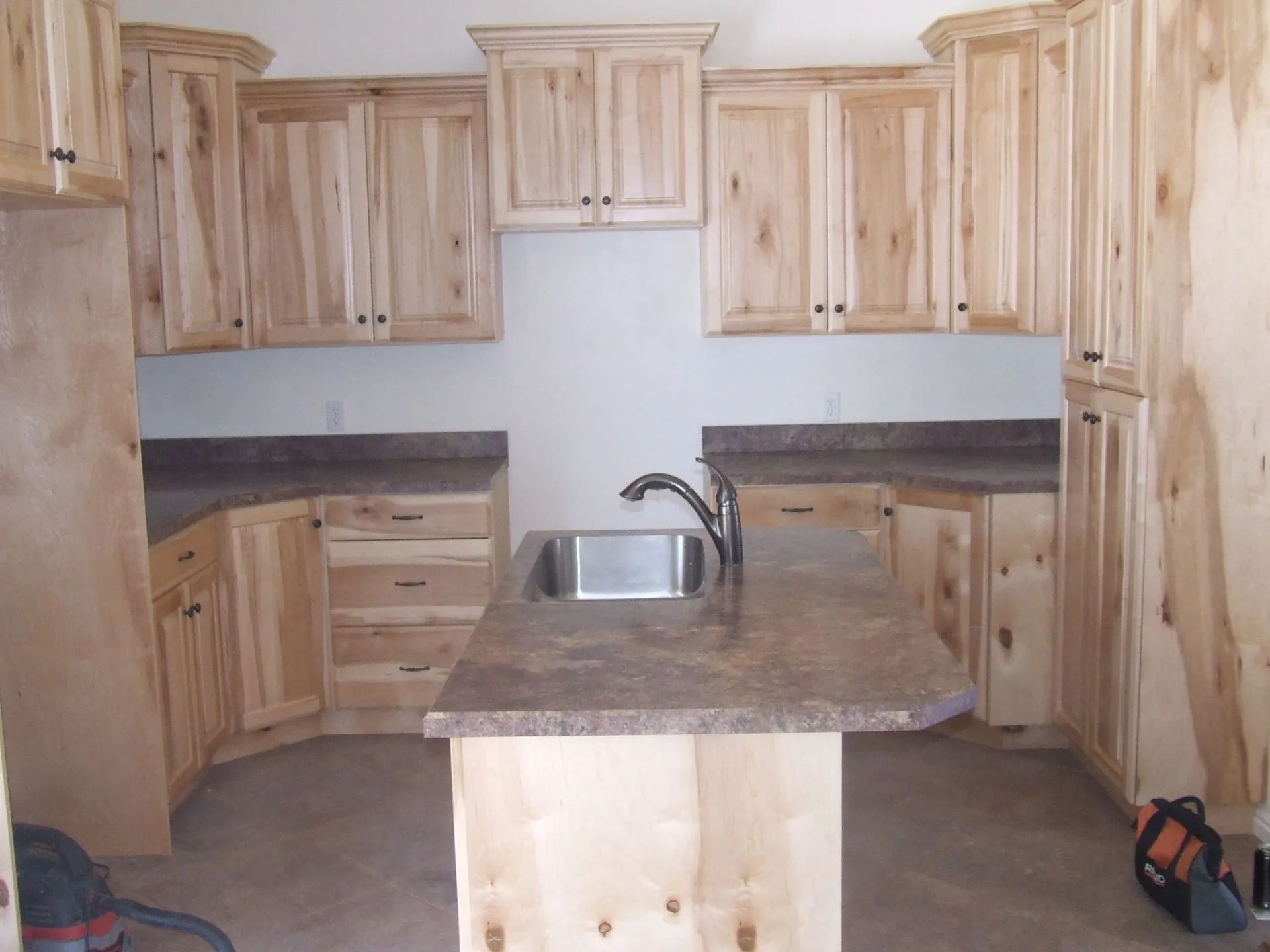 A kitchen with wooden cabinets and granite counter tops.