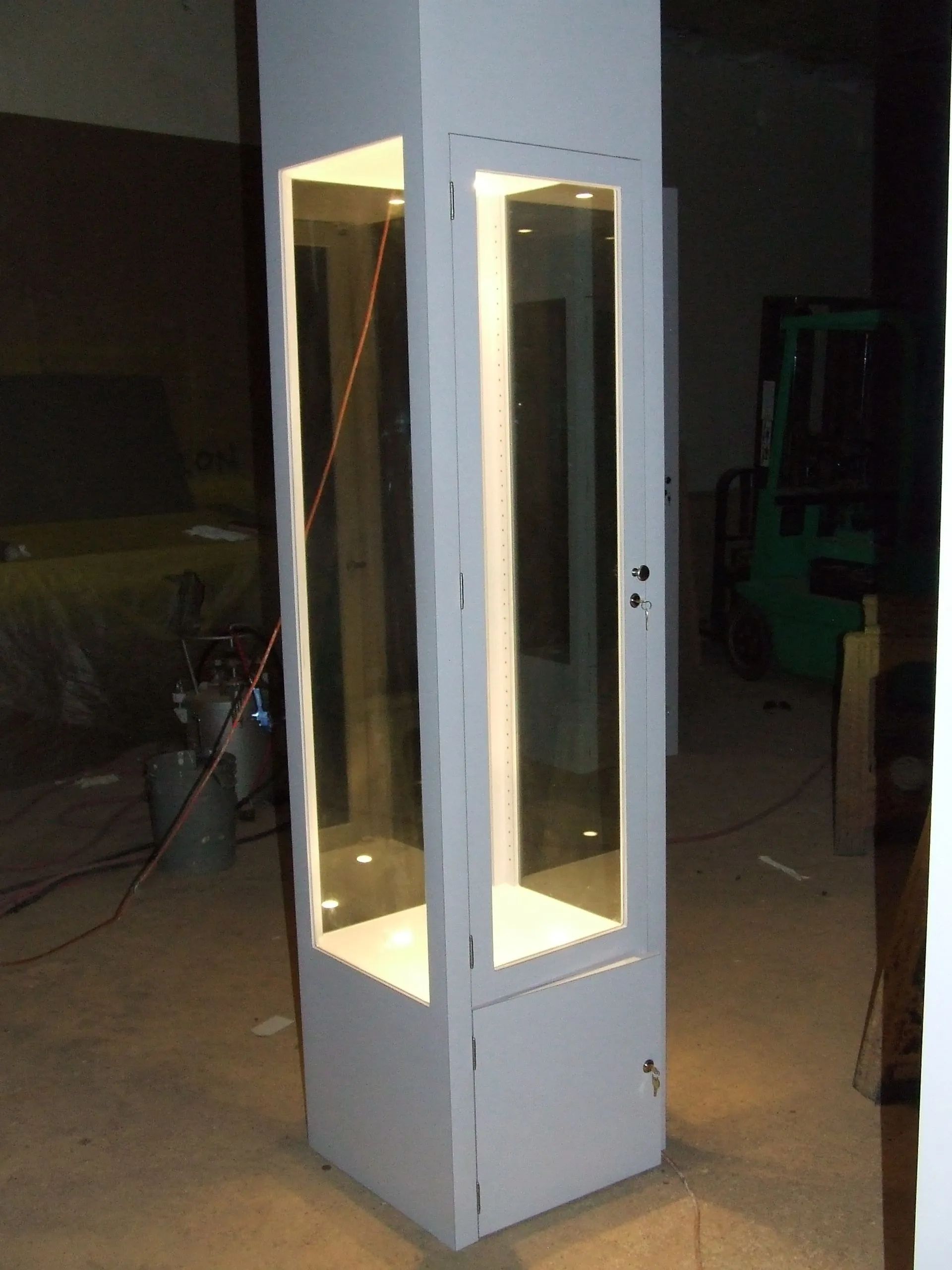 A tall white cabinet with a glass door.