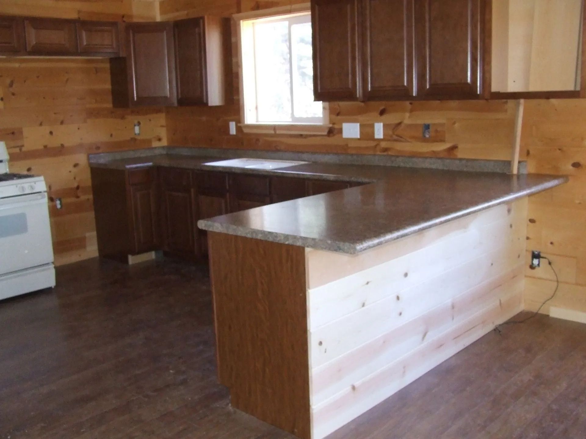 A kitchen with wooden cabinets and granite counter tops.