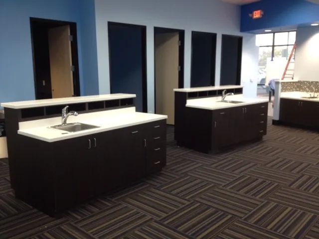 A kitchen with two sinks and a carpeted floor.