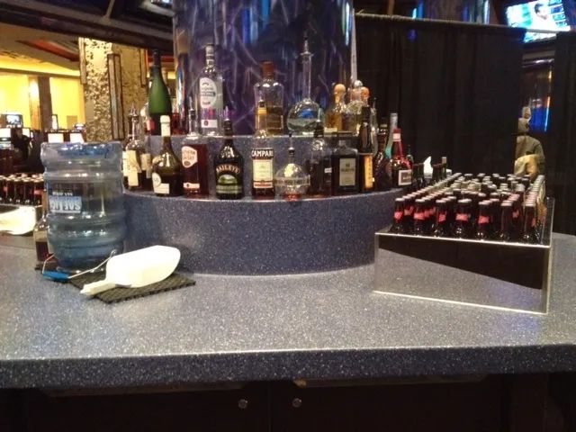 A bar with bottles of liquor and a pitcher of water.