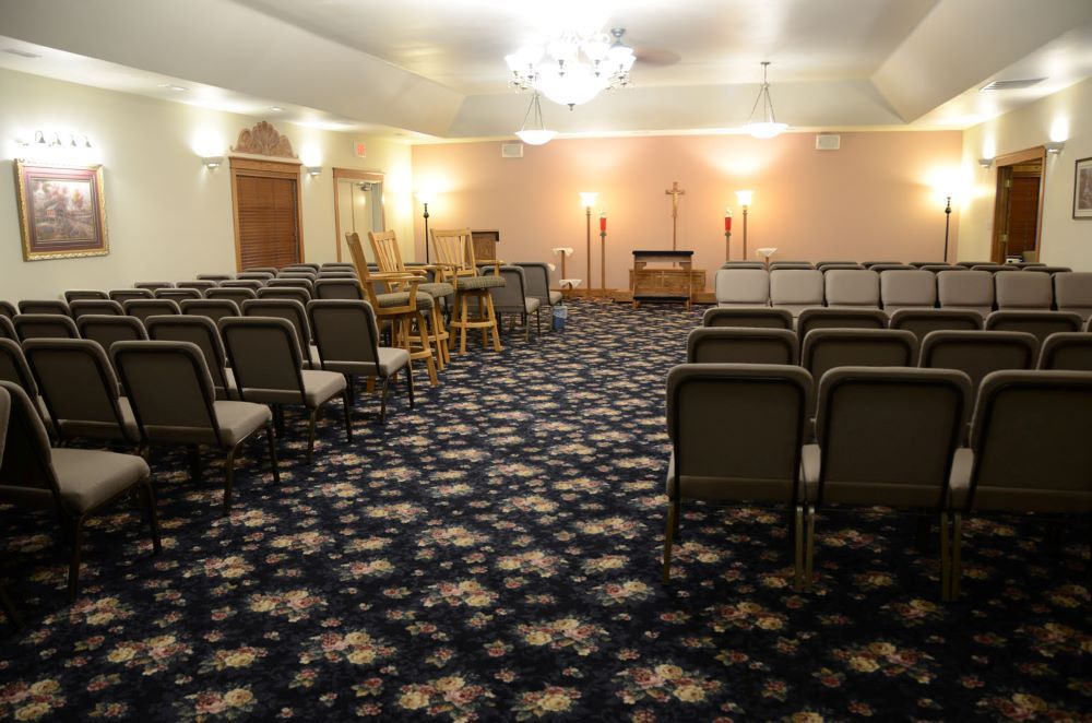 A large room with rows of chairs and a chandelier.
