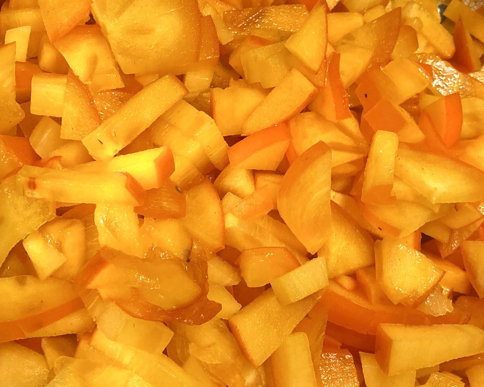 Gesneden gele en oranje fruitstukjes.