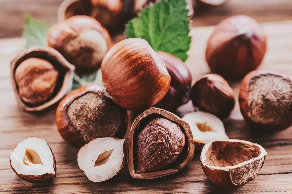 Hazelnoten, sommige gepeld, op een houten ondergrond.