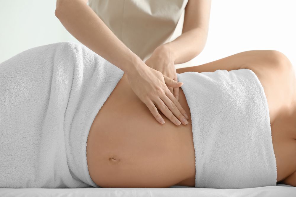 The Massage Therapist Makes a Belly Massage to a Pregnant Young Woman — Massage Therapy in Kirwan, QLD