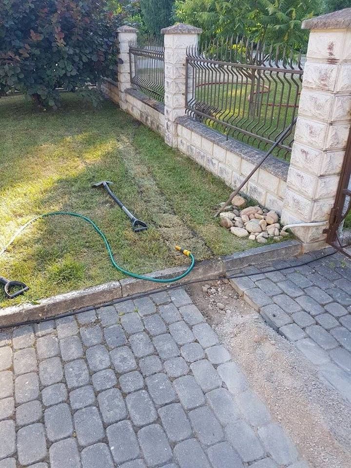 Šalia mūrinio tako ant žemės guli žarna.