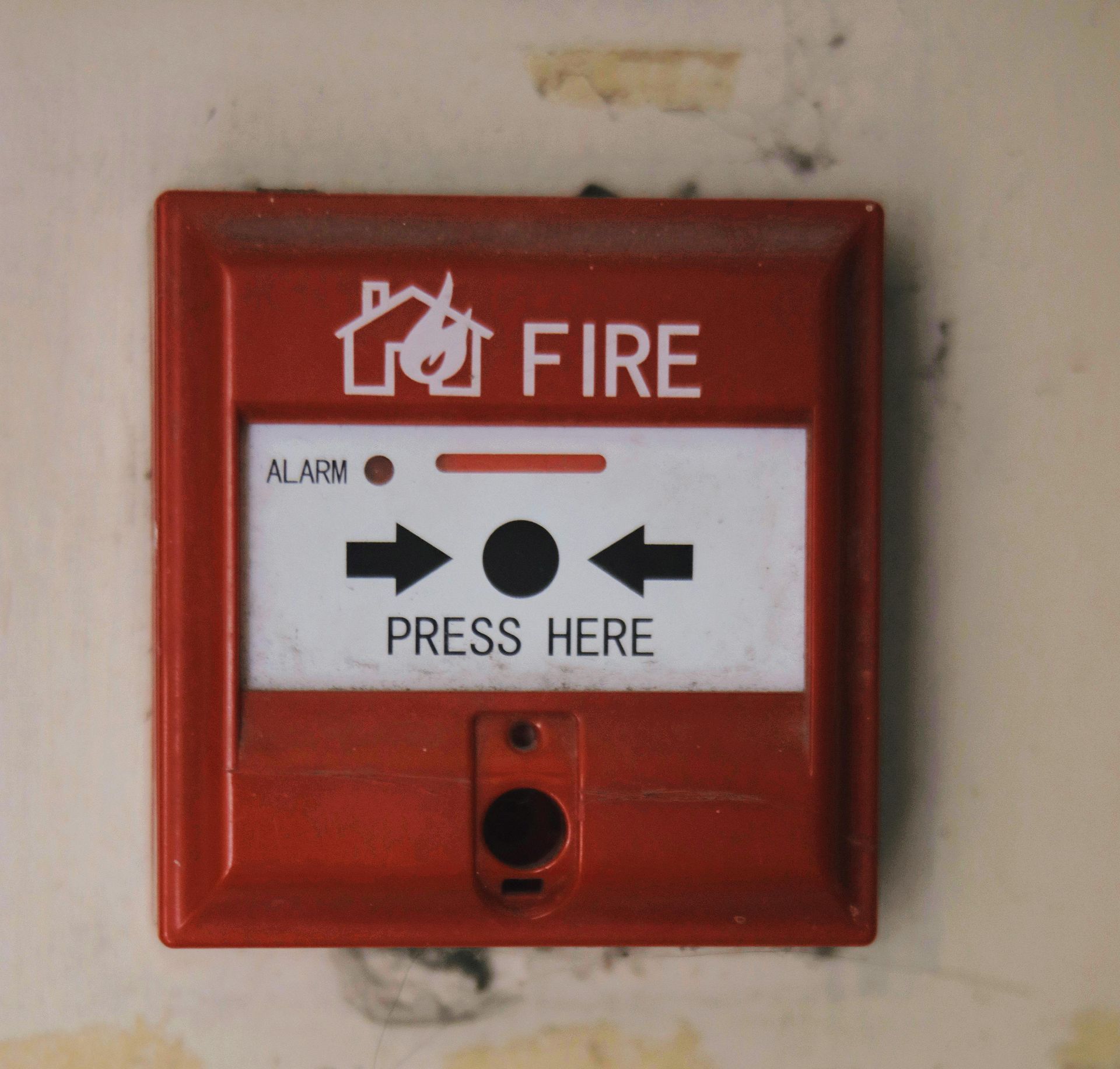 A red fire alarm button that says press here