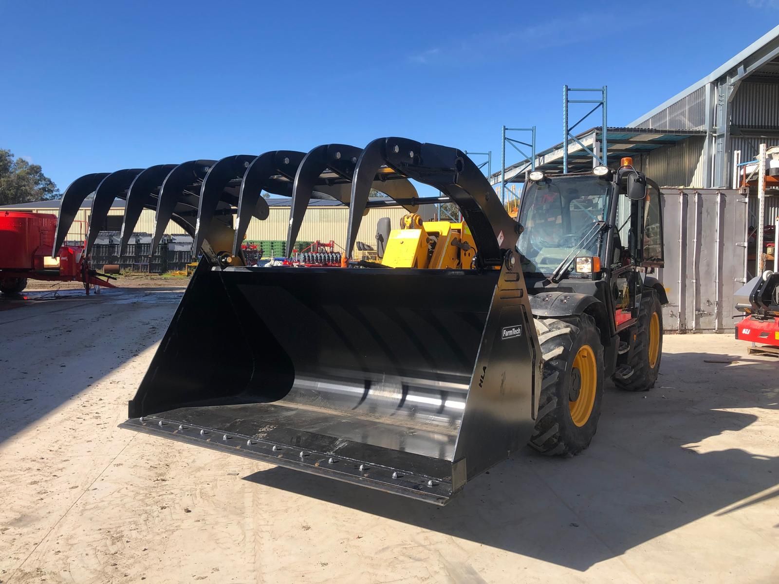 A large bale of hay is being lifted by a machine.